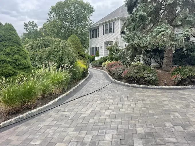 Freshly paved asphalt courtyard behind a home with French doors